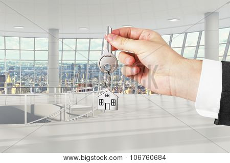 Man Hand With Keys With Light Empty Office On Background