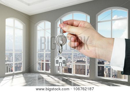 Man With Key In Hand In Modern Empty Room With Concrete Floor
