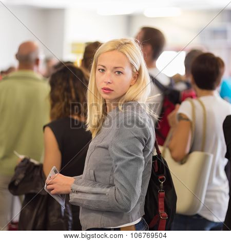 Young blond caucsian woman waiting in line.