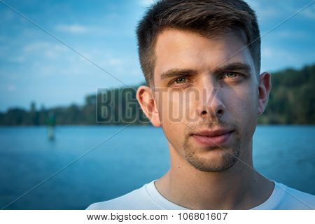 Young man standing on the bank of the river
