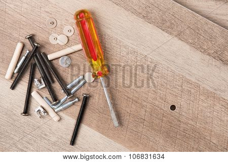 Screwdriver And Hardware Scattered On Wood Planks