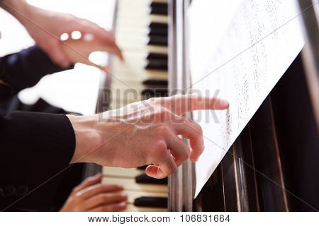 Close up of musician man and girl hands piano playing