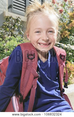 Happy little girl outside with backpack
