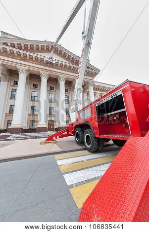 Builders paint building facade by fire truck