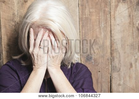 depress senior person with wood background