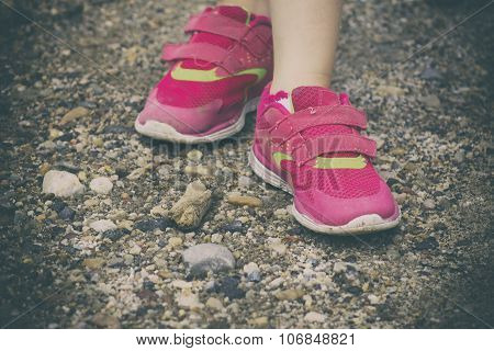 young girl standing on a rock path while on a walk with her family