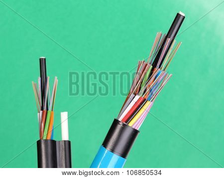 Two fiber optic loose tube cables with stripped ends and bare exposed colored optical fibers