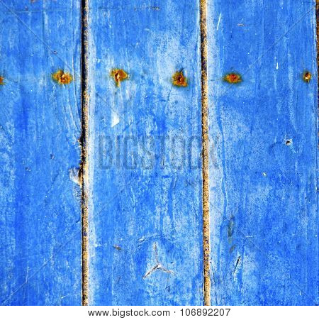 Stripped Paint In The Blue Wood Door And Rusty Nail