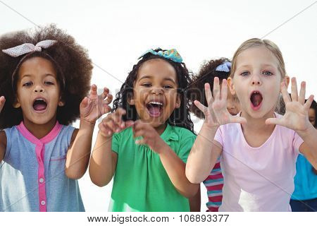 Scarey girls with hands raised against a white background