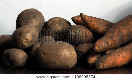 Carrots and potatoes unpeeled on the table