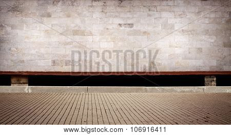 Weathered cinder block, brick wall texture with sidewalk.
