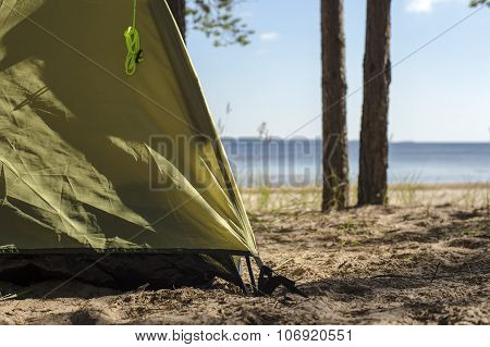 edge of tourist tents, which stands on a sandy beach near the water