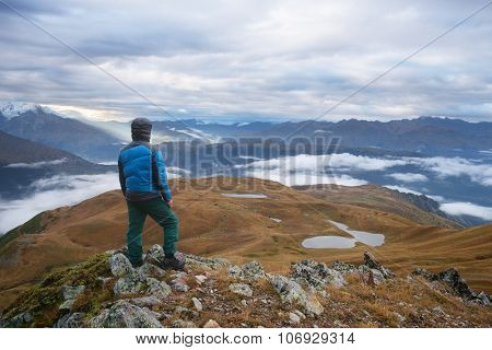 Tourists in a hike. Mountain landscape. View of the lake Koruldi. Main Caucasian ridge. Zemo Svaneti, Georgia 