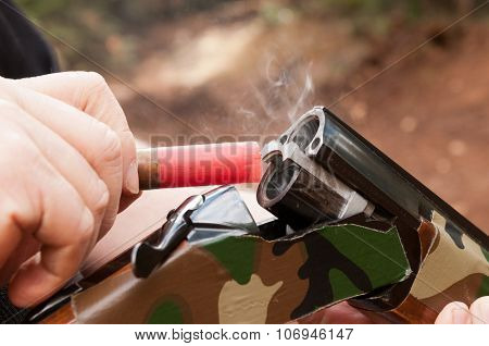 Smoking gun concept,  a double barreled over/under shotgun immediately after firing with shallow depth of field focused on the smoke leaving the breech