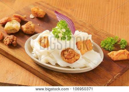 plate of lard and greaves on wooden cutting board
