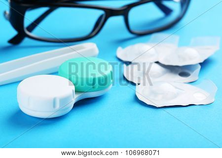 Contact Lenses In Container With Solution On Blue Background
