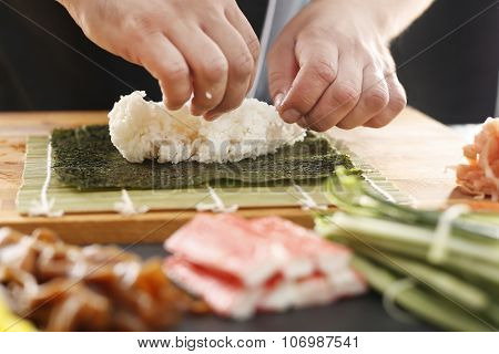 Sushi master prepares futomaki