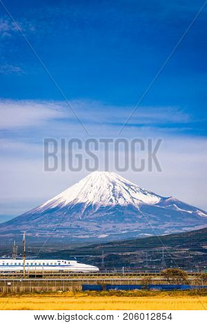 JAPAN - DECEMBER 14, 2012: A Shinkansen bullet train passes below Mt. Fuji in Japan.