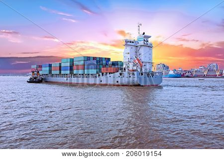 Container ship on the Yangon river near Yangon in Myanmar at sunset