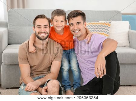 Homosexual male couple with foster son at home. Adoption concept