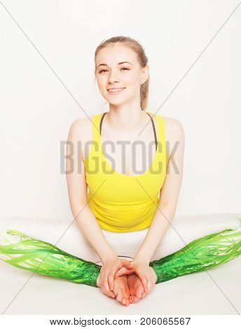 lifestyle, sport  and people concept: young woman in yoga pose sitting on a floo
