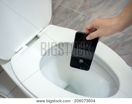Chiangrai Thailand: August 23 2017 - Human hand picking wet Apple iPhone 7 Plus from flush toilet.