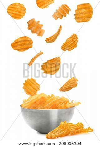 Tasty potato chips falling into bowl on white background