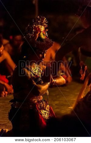 Ubud, Indonesia - August 29, 2016: Beautiful balinese woman dances during a traditional Kecak Fire Dance ceremony in Hindu temple.