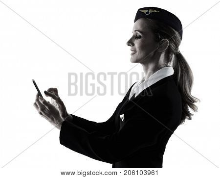 one caucasian Stewardess cabin crew  woman on the phone isolated on white background in  silhouette