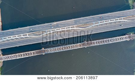 Aerial top view of automobile and railroad Darnitsky bridge across Dnieper river from above, Kiev (Kyiv) city skyline, Ukraine