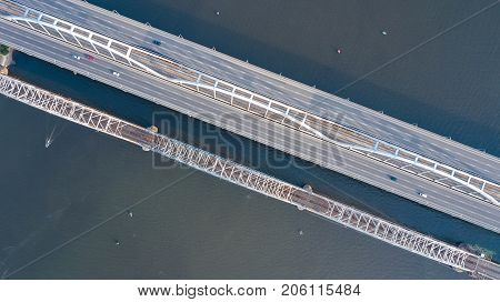 Aerial top view of automobile and railroad Darnitsky bridge across Dnieper river from above, Kiev (Kyiv) city skyline, Ukraine