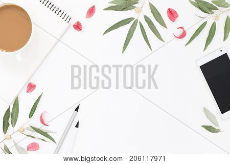 Round composition with cell phone cup of coffee notepad and plants. Lifestyle flat lay.