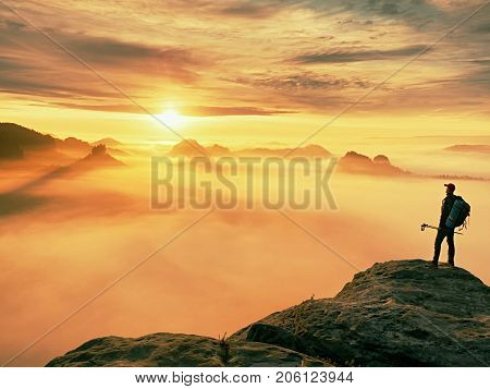 Man Silhouette With Poles In Hand. Sunny Spring Daybreak And Tourist Guide Stay On Sharp Cliff Of Mo
