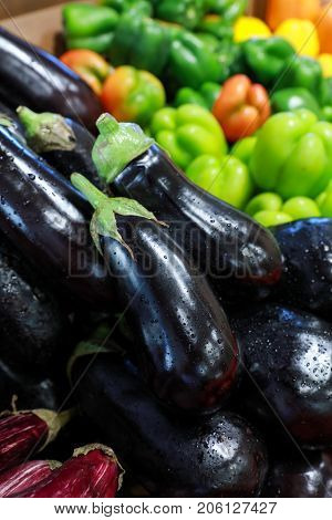 Fresh eggplants and peppers on the counter in the greek grocery shop. Vertical. Close-up.