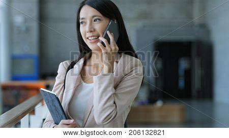 Business woman talk to cellphone and holding tablet computer