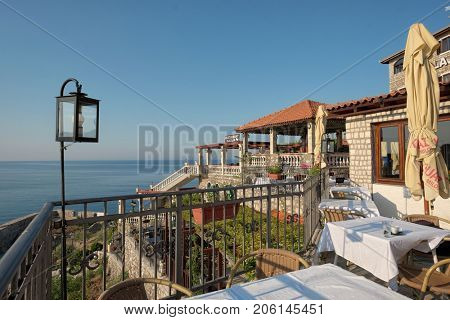ULCINJ, MONTENEGRO - JULY 13, 2017: sunny restaurant terraces overlooking the sea of Ulcinj Old Town, Montenegro