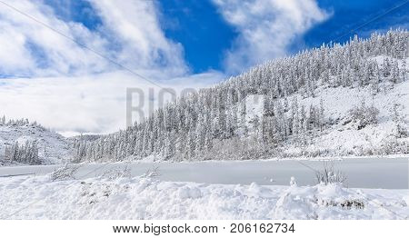 Beautiful lake Amut in taiga hills on Far East of Russia in early october. Mountain lake in winter. Beautiful nature. Snowy weather.