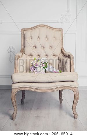 Bridal bouquet lying on the chair in white studio