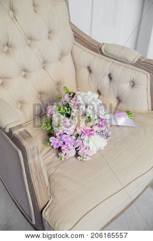 Bridal bouquet lying on the chair in white studio
