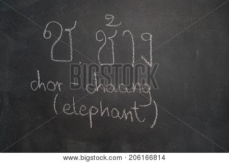 Thai letter written with white chalk on blackboard