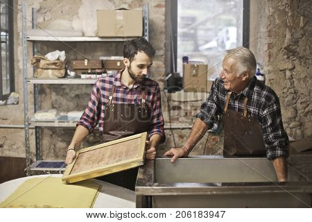 Elderly artisan and young apprentice at work
