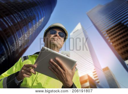 Construction engineer wearing safety vest with buildning  in the background