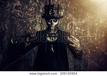 A man with a skull makeup dressed in a tail-coat and a top-hat. Baron Saturday. Baron Samedi. Dia de los muertos. Day of The Dead. Halloween.