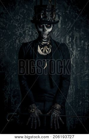 A man with a skull makeup dressed in a tail-coat and a top-hat. Baron Saturday. Baron Samedi. Dia de los muertos. Day of The Dead. Halloween.