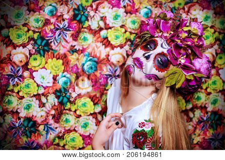 Dia de los muertos. Day of The Dead. Woman with sugar skull makeup on a floral background. Calavera Catrina. Halloween.