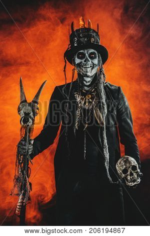 A man with a skull makeup dressed in a tail-coat and a top-hat. Baron Saturday. Baron Samedi. Dia de los muertos. Day of The Dead. Halloween.