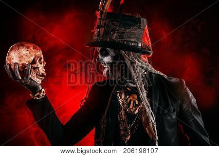 A man with a skull makeup dressed in a tail-coat and a top-hat. Baron Saturday. Baron Samedi. Dia de los muertos. Day of The Dead. Halloween.