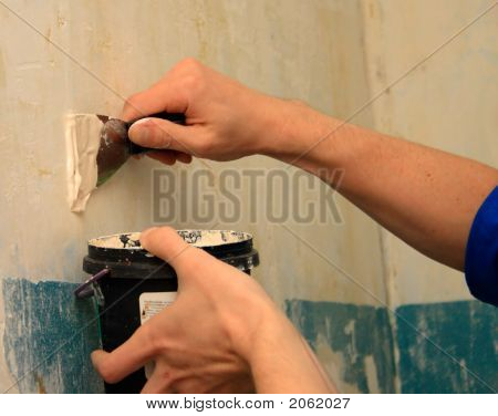 menschlicher Arm repariert eine Wand