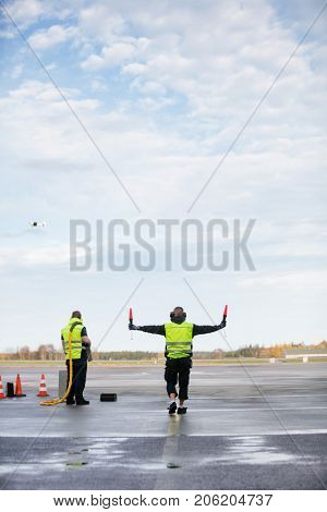 Marshaller Holding Signal Wands While Standing By Colleague On R