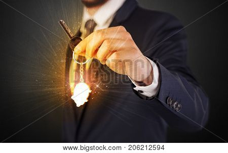 Formal man hand over shiny keys with dark background